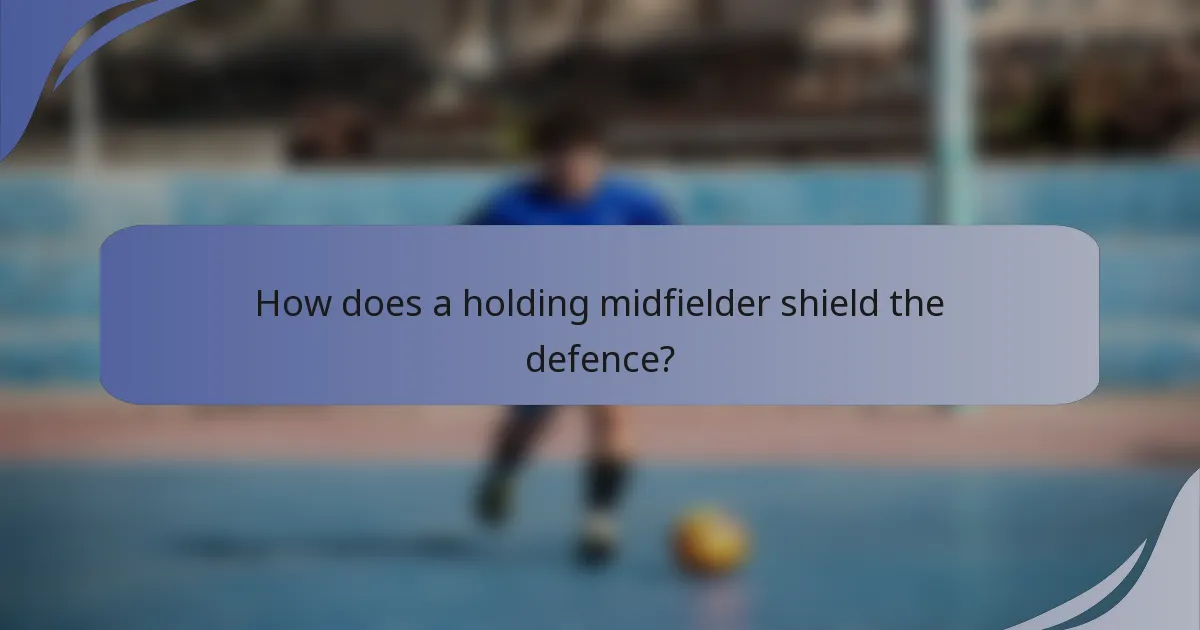 How does a holding midfielder shield the defence?
